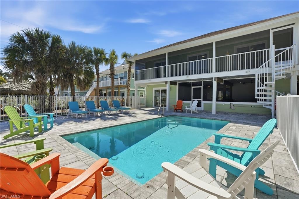 View of swimming pool with patio surround, a balcony, and a sunroom - Virtually Edited Image