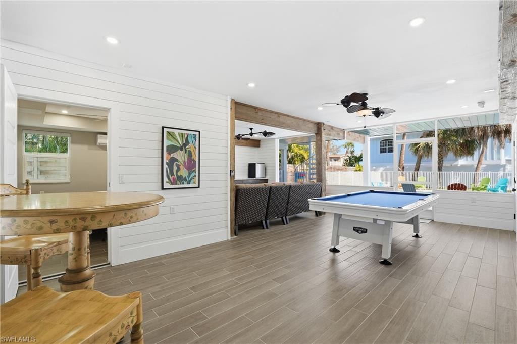 Rec room with wood tiled floors, wood walls, recessed lighting, ceiling fan, and billiards - Virtually Edited Image