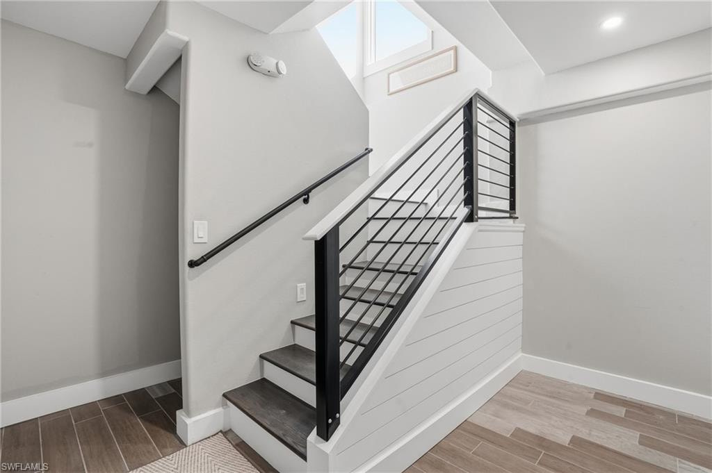 Stairway featuring wood tiled floors and baseboards - Virtually Edited Image
