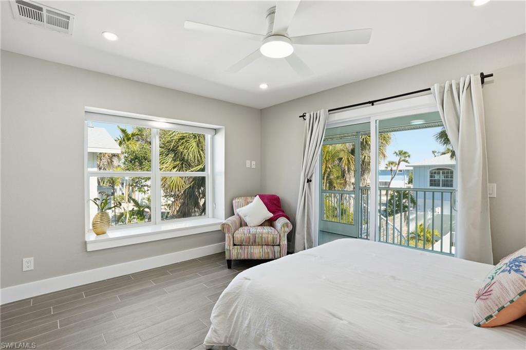 Bedroom featuring wood tiled floors, recessed lighting, a ceiling fan, and access to exterior - Virtually Edited Image
