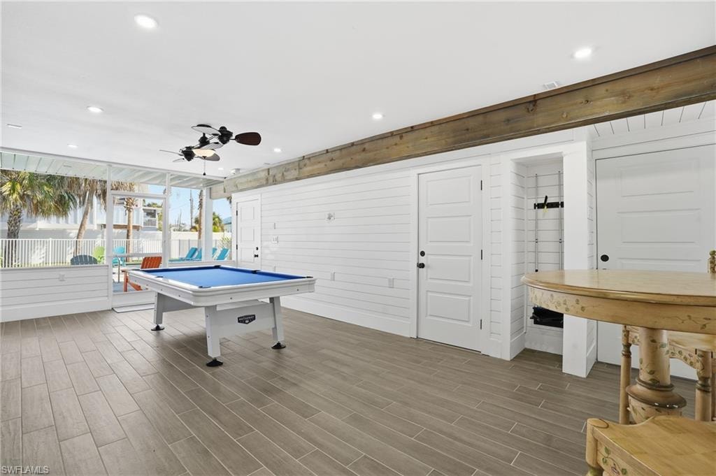 Playroom featuring a ceiling fan, wood walls, wood finish floors, billiards table, and recessed lighting - Virtually Edited Image