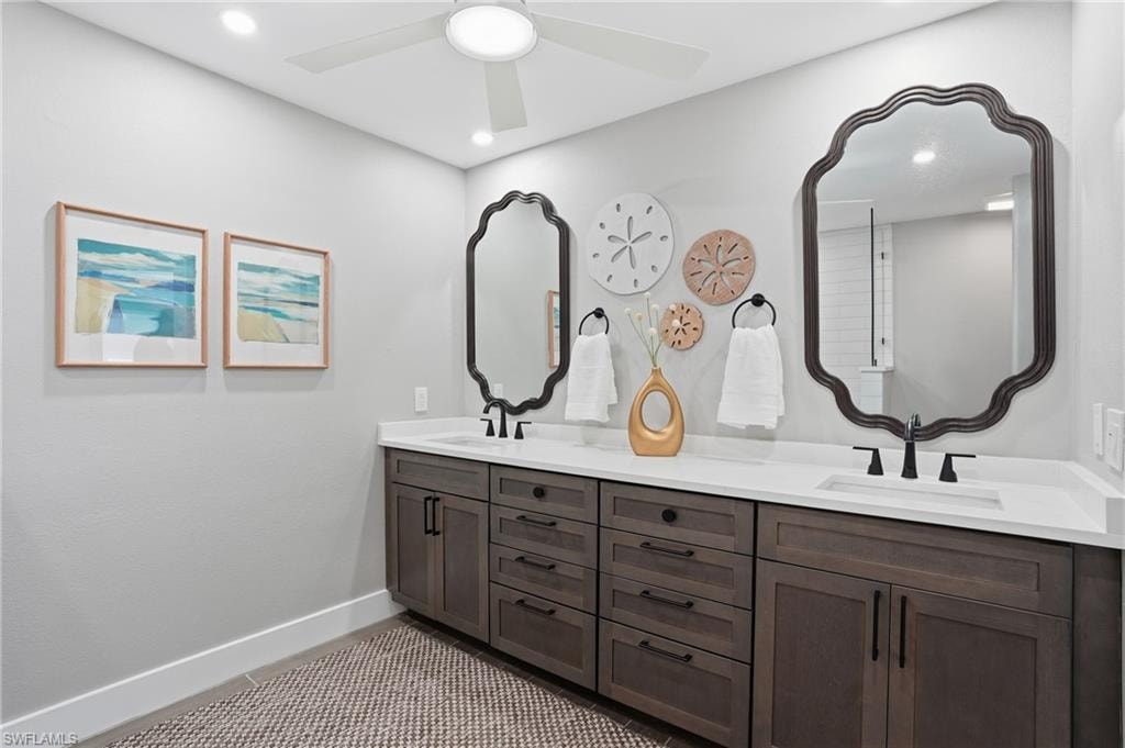 Bathroom featuring double vanity, ceiling fan, and recessed lighting - Virtually Edited Image
