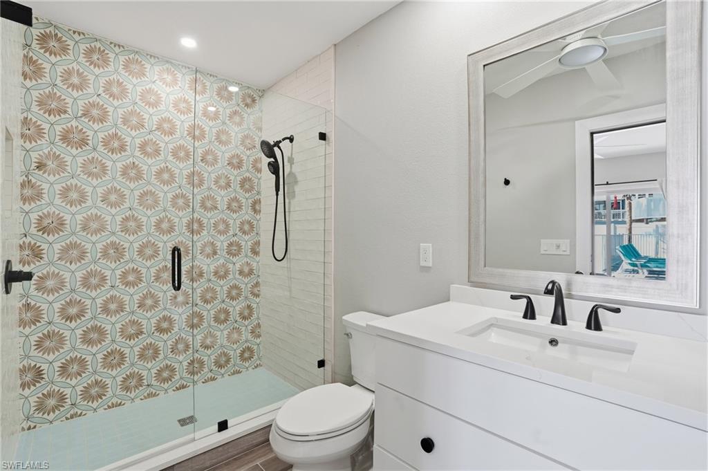 Full bathroom featuring a shower stall, vanity, recessed lighting, and ceiling fan - Virtually Edited Image