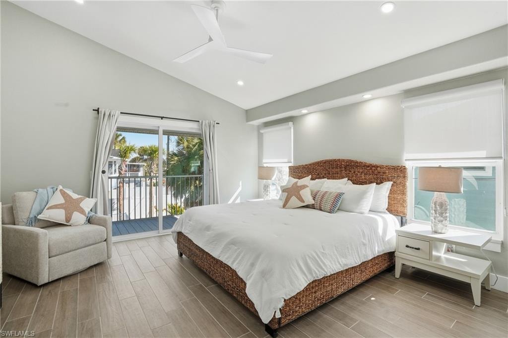 Bedroom with wood finish floors, vaulted ceiling, a ceiling fan, access to exterior, and recessed lighting - Virtually Edited Image