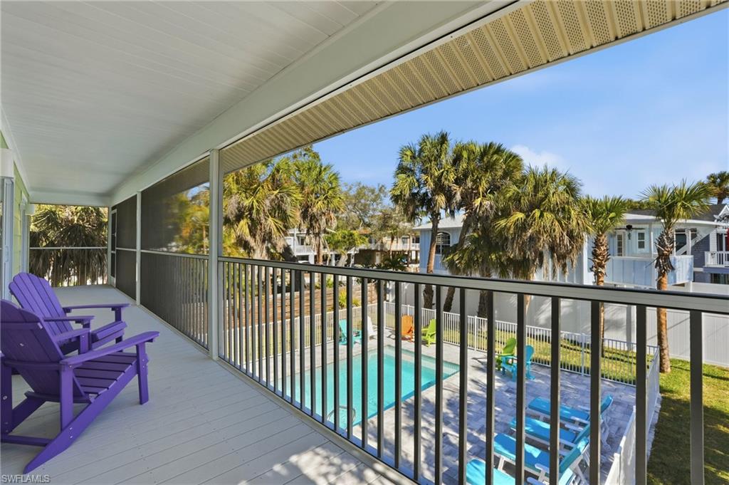 Balcony featuring view of pool and a sunroom - Virtually Edited Image