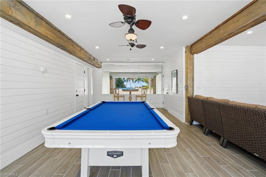 Recreation room featuring wood finish floors, wooden walls, billiards, a ceiling fan, and recessed lighting - Virtually Edited Image