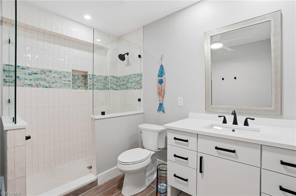 Full bathroom with vanity, walk in shower, and dark wood-style flooring - Virtually Edited Image