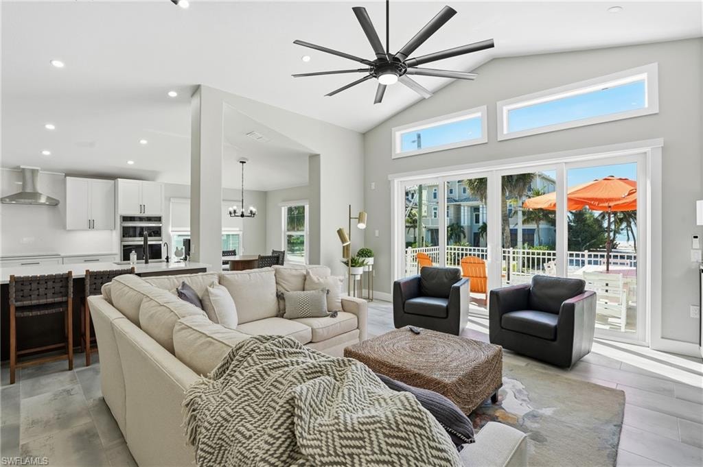 Living area featuring a ceiling fan, suspended lighting, and vaulted ceiling - Virtually Edited Image
