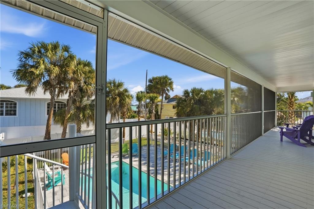 Balcony featuring view of pool and a sunroom - Virtually Edited Image