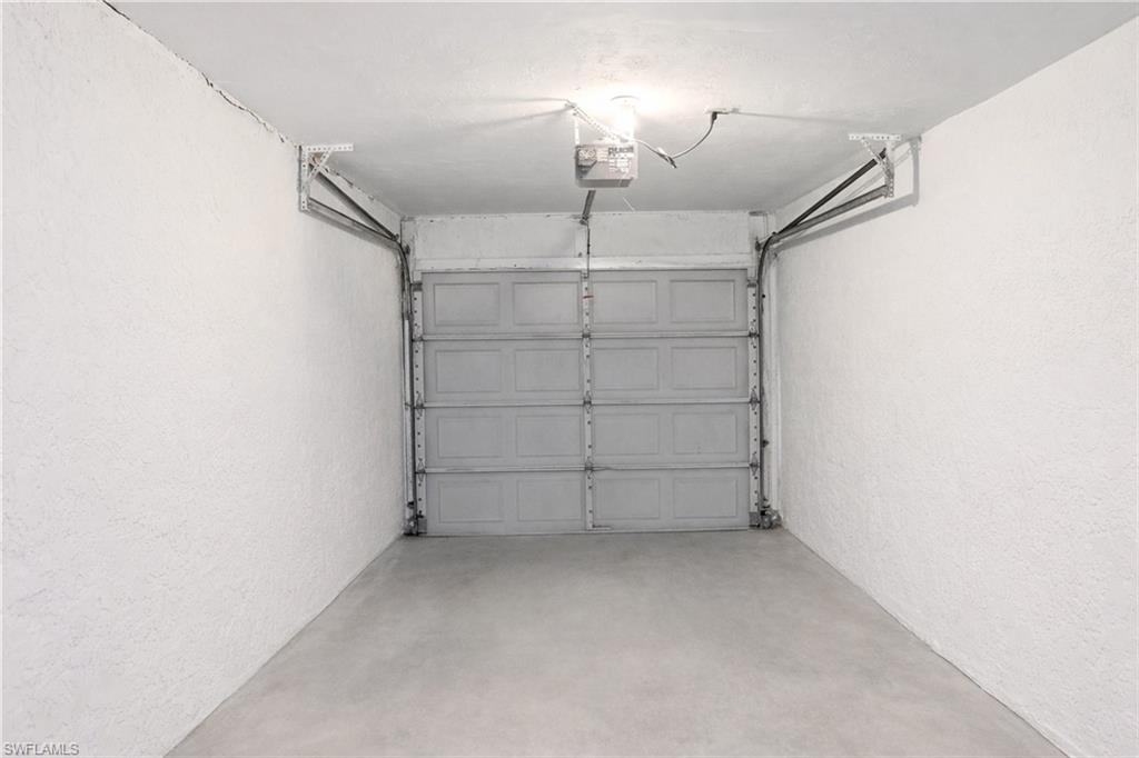 Garage with a textured wall and a garage door opener