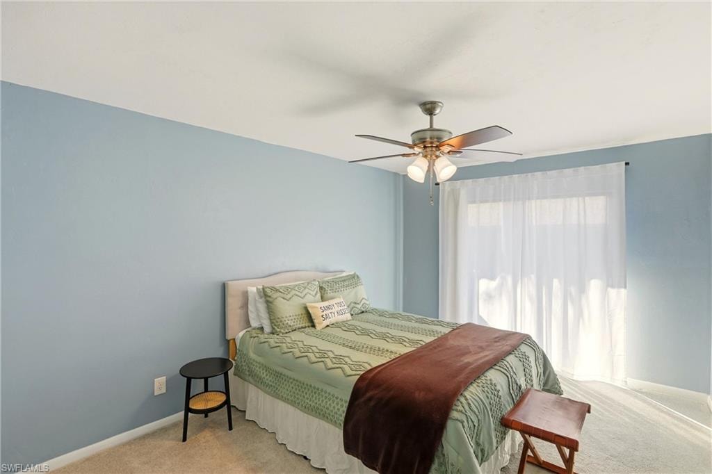 Carpeted bedroom with baseboards and a ceiling fan