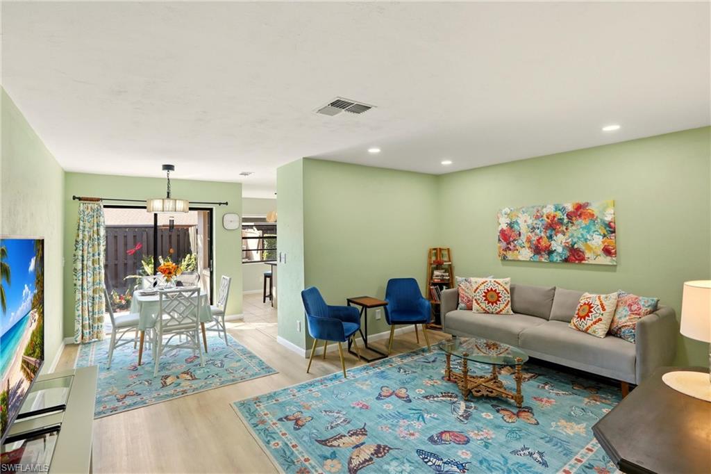 Living room with light wood finished floors and recessed lighting