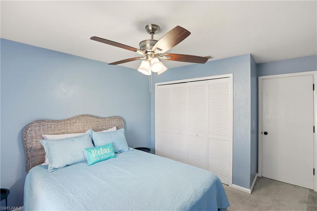Bedroom featuring light carpet, a closet, and a ceiling fan