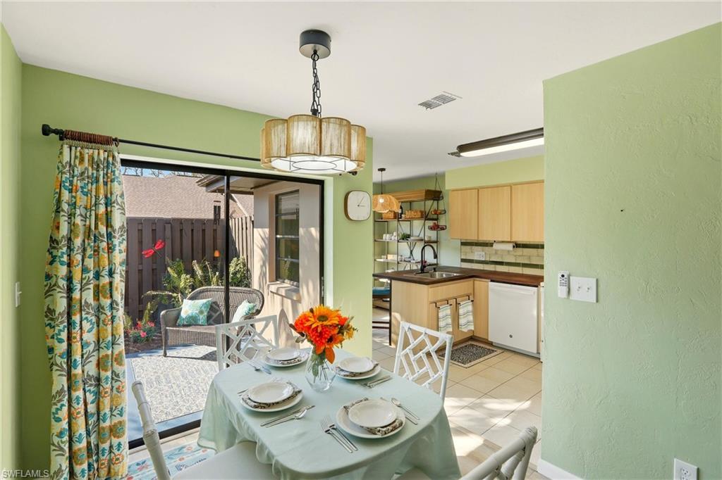 Dining space with light tile patterned flooring and a textured wall
