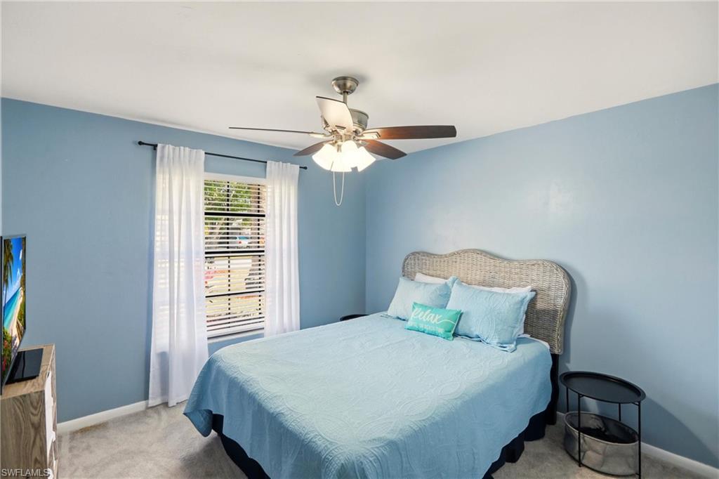 Carpeted bedroom featuring a ceiling fan and baseboards