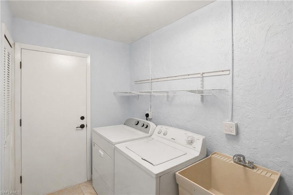 Laundry area with a textured wall and washer and dryer