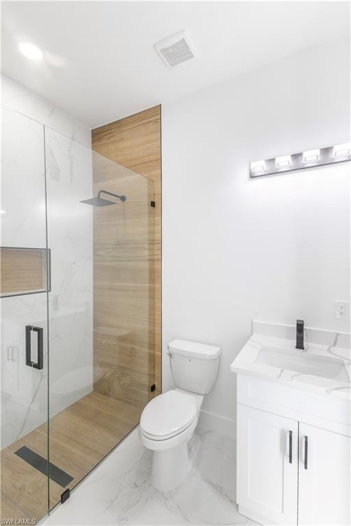 Bathroom with a marble finish shower, vanity, and marble finish flooring