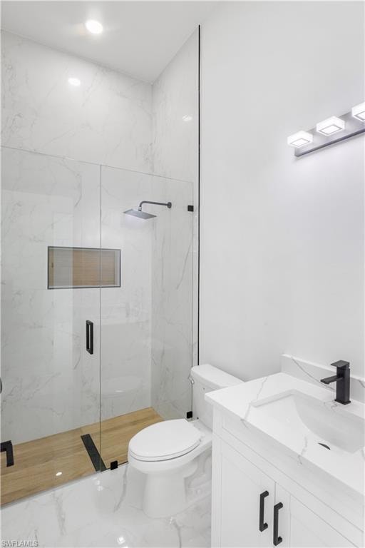 Bathroom with a marble finish shower, vanity, and marble finish flooring