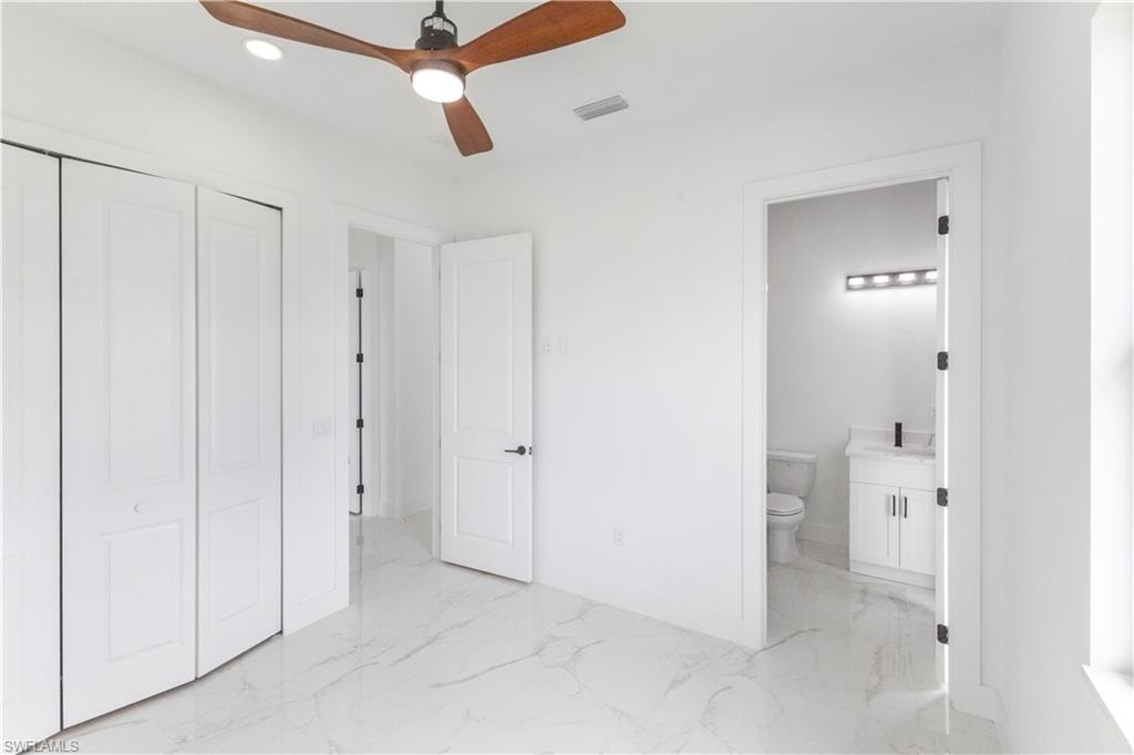 Unfurnished bedroom with a closet, light marble finish flooring, a ceiling fan, and recessed lighting