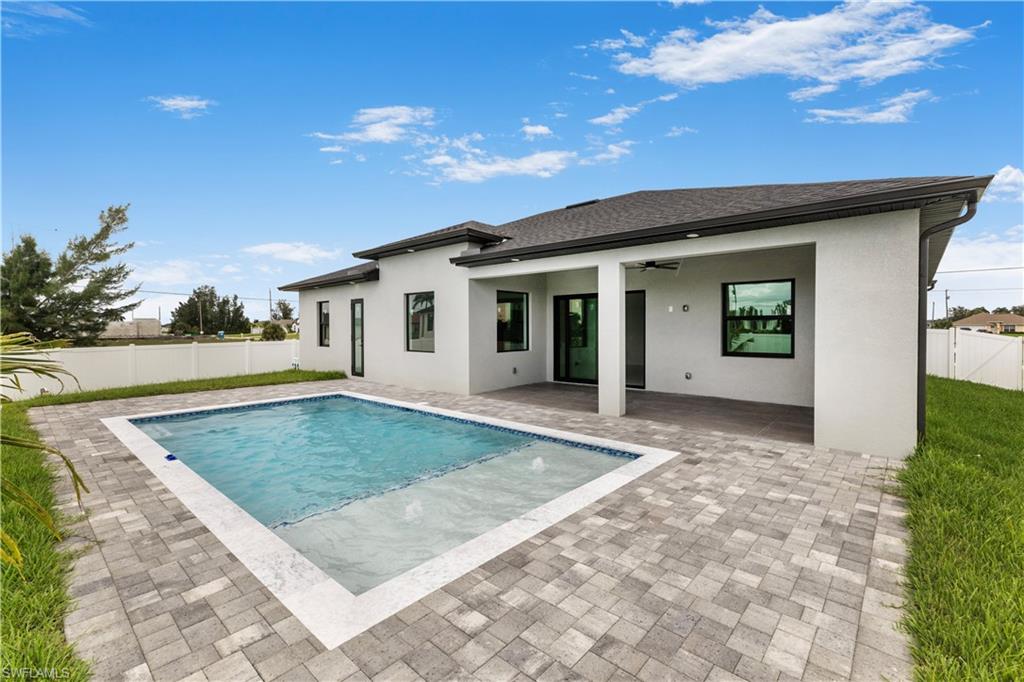 Back of property featuring a fenced backyard, ceiling fan, a patio, stucco siding, and roof with shingles
