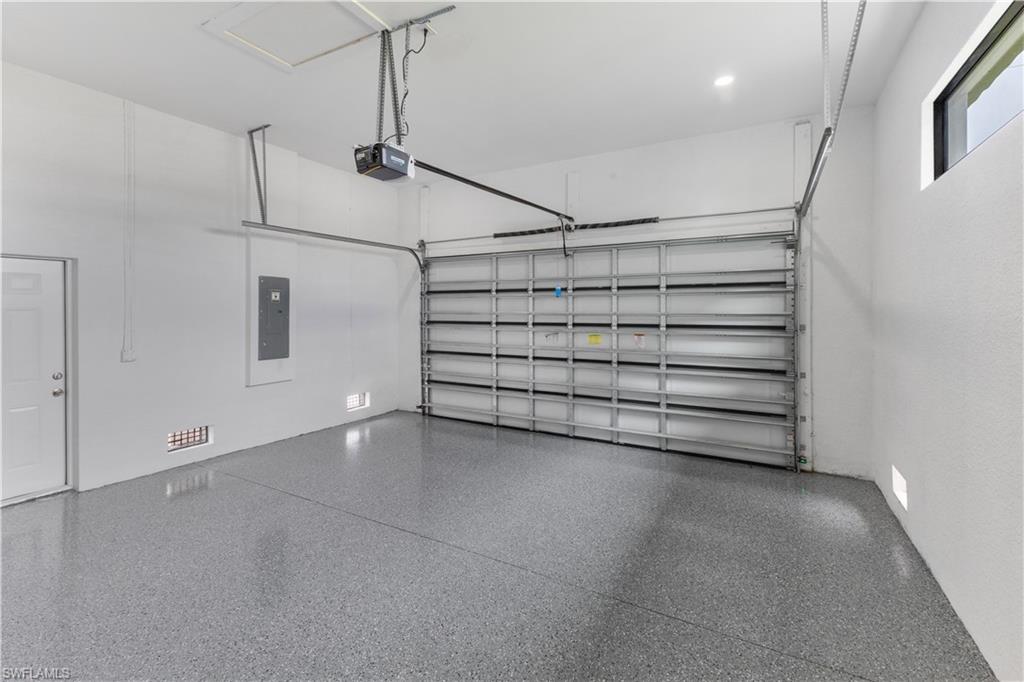 Garage featuring electric panel and a garage door opener