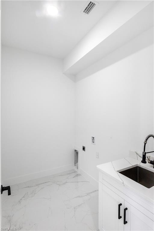 Laundry area with electric dryer hookup, cabinet space, hookup for a washing machine, and light marble finish floors