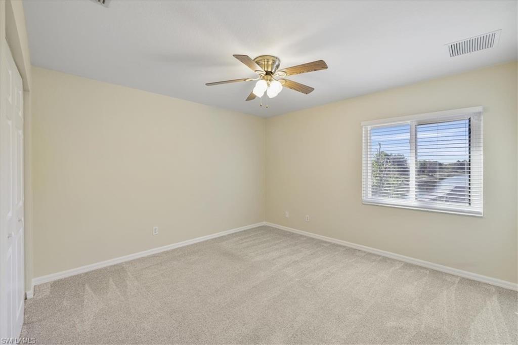 Empty room with light carpet and ceiling fan