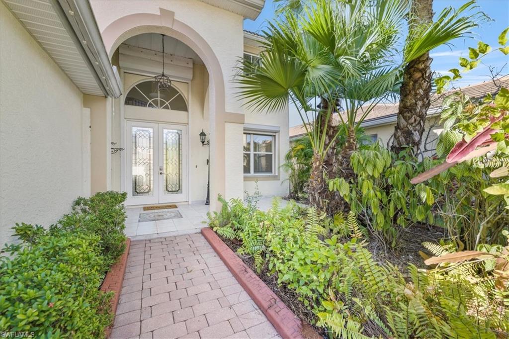 Doorway to property featuring stucco siding and french doors