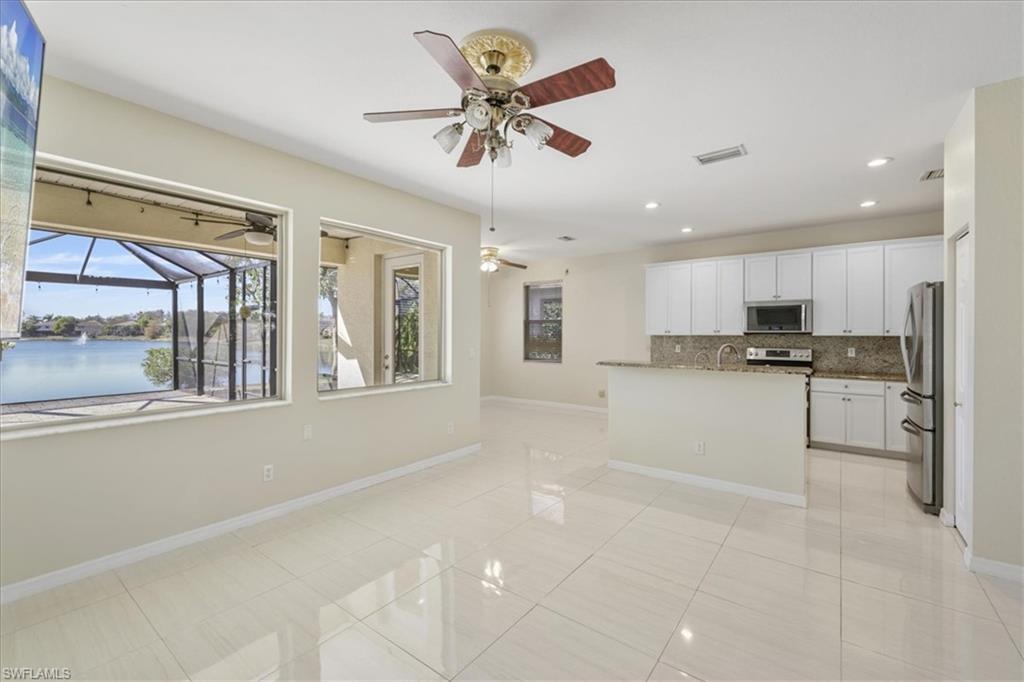 Kitchen featuring white cabinetry, a center island with sink, recessed lighting, tasteful backsplash, and stainless steel appliances
