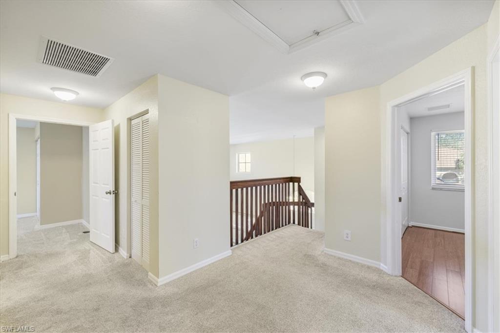 Hallway featuring light carpet and an upstairs landing