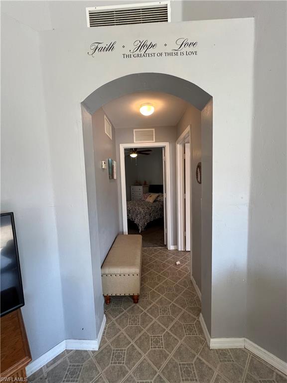 Hall with arched walkways and baseboards