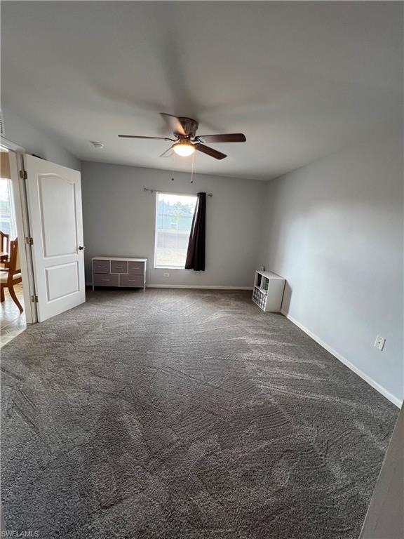 Unfurnished room with carpet flooring, ceiling fan, and heating unit