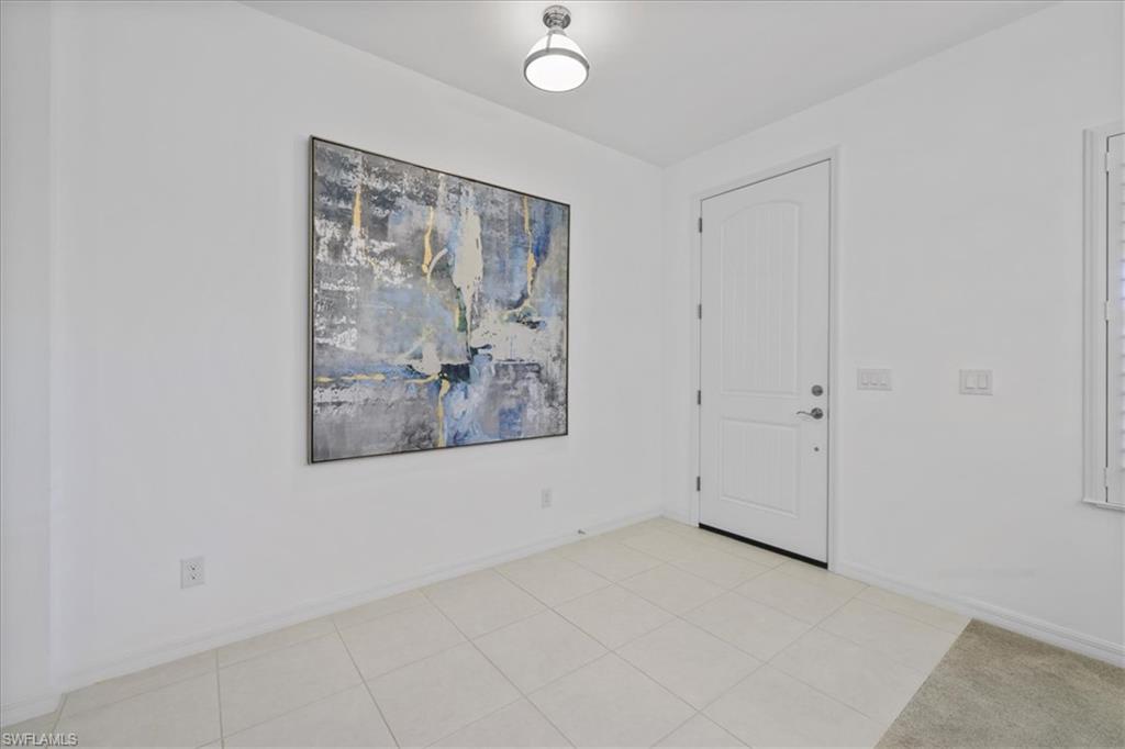 Foyer entrance featuring baseboards and light tile patterned flooring