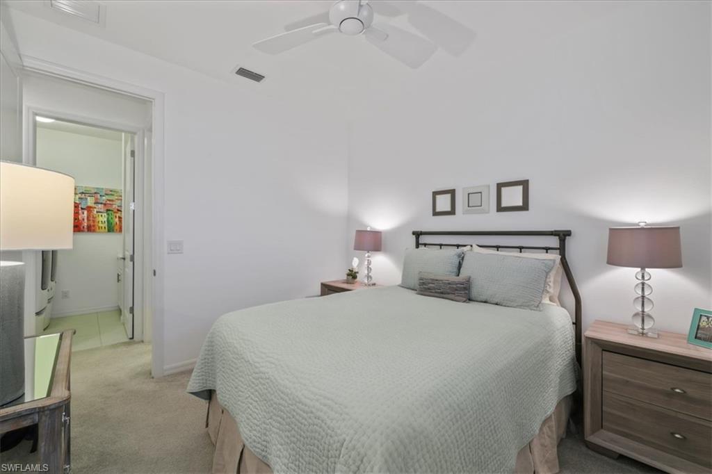 Bedroom with light carpet and a ceiling fan