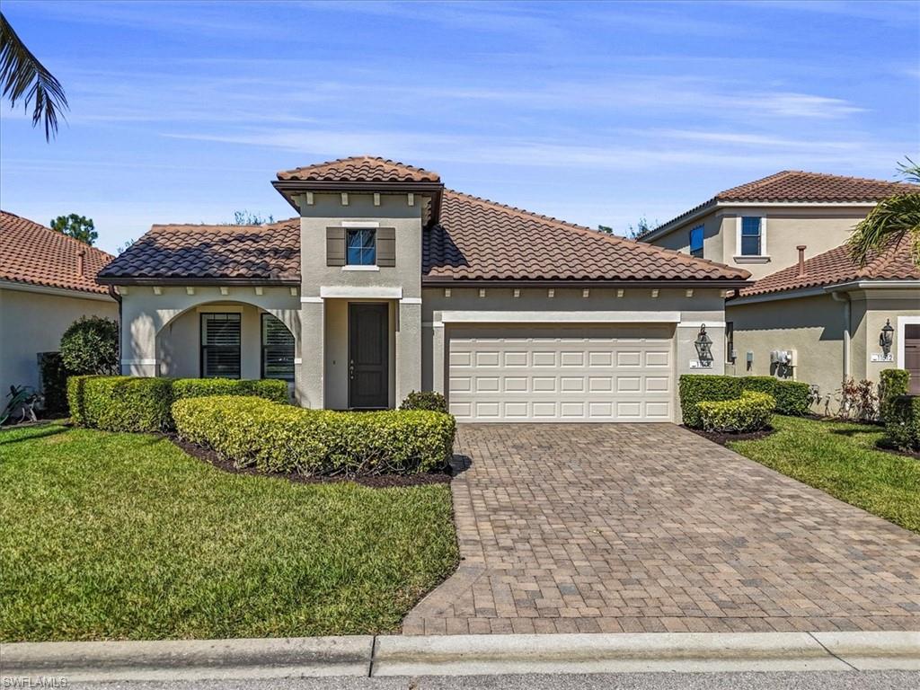Mediterranean / spanish house featuring a front yard, stucco siding, an attached garage, decorative driveway, and a tile roof