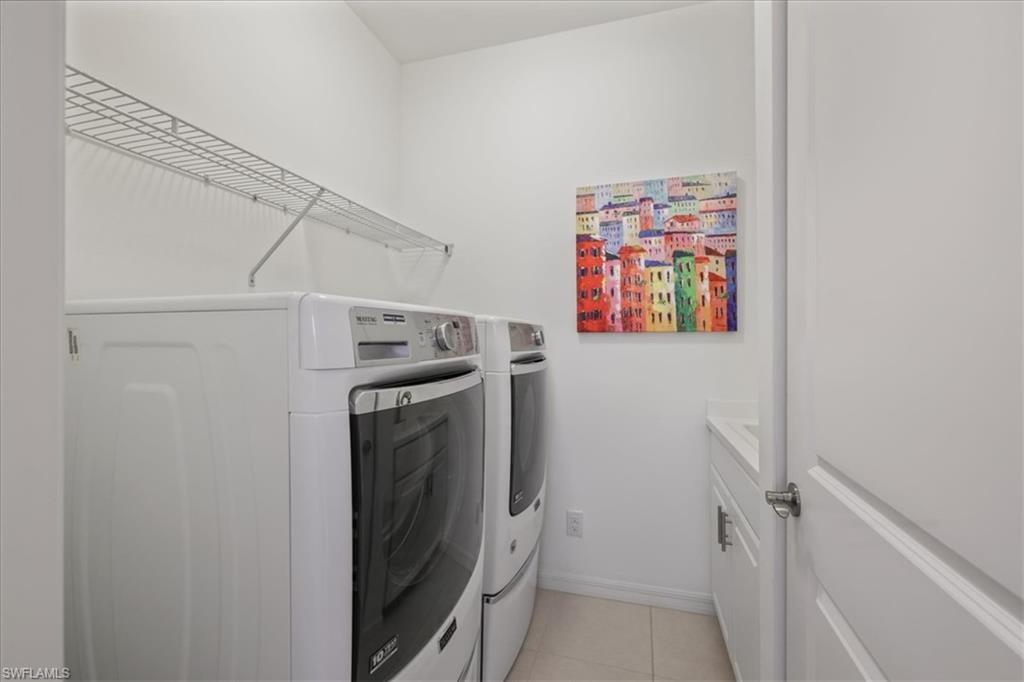 Laundry room featuring washer and clothes dryer and light tile patterned floors