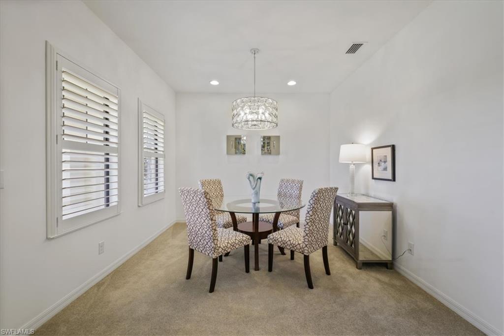 Carpeted dining room featuring baseboards and suspended lighting