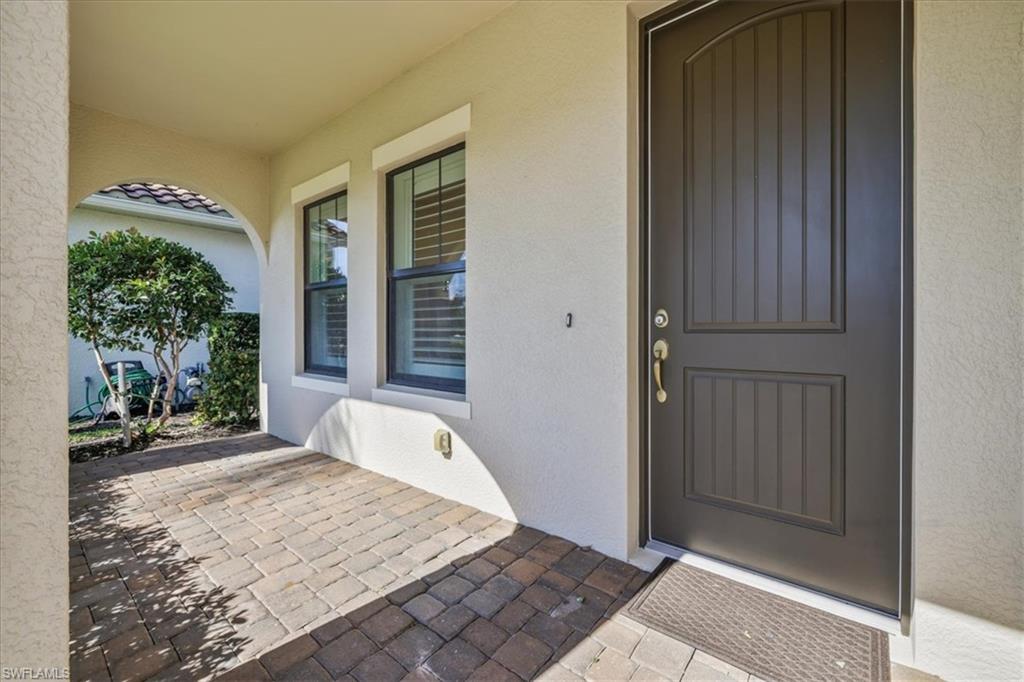Property entrance with stucco siding and a patio
