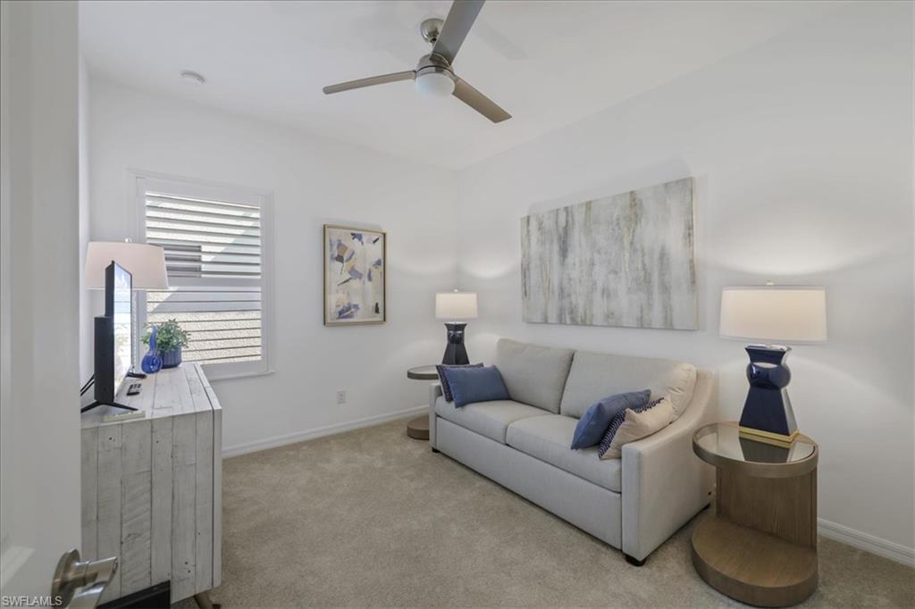 Living area featuring carpet floors and a ceiling fan