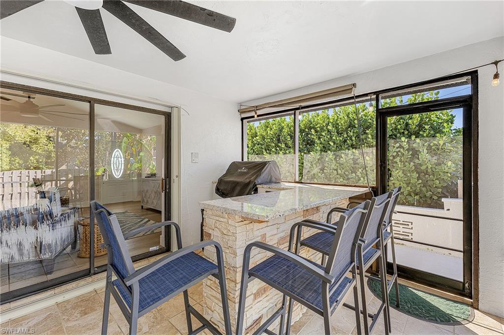 outdoor kitchen with gas grill, beverage fridge & 4 barstools