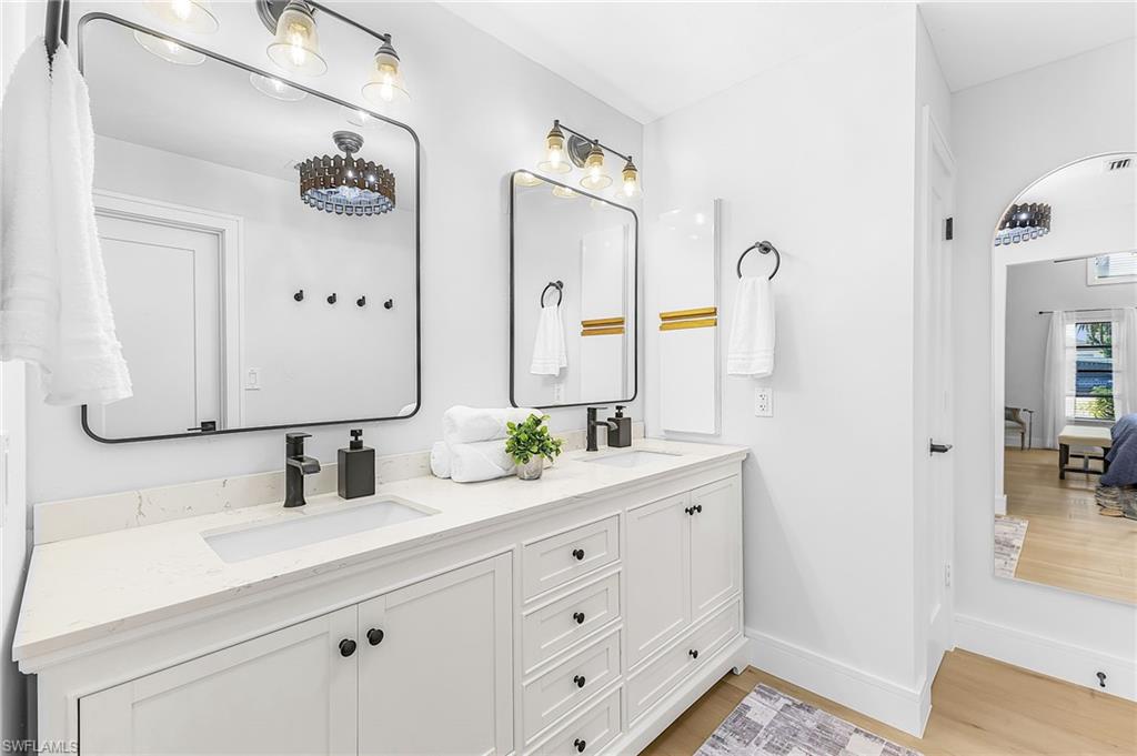 Primary bath featuring a modern raised double vanity, quartz countertop with black hardware and a ceiling fan