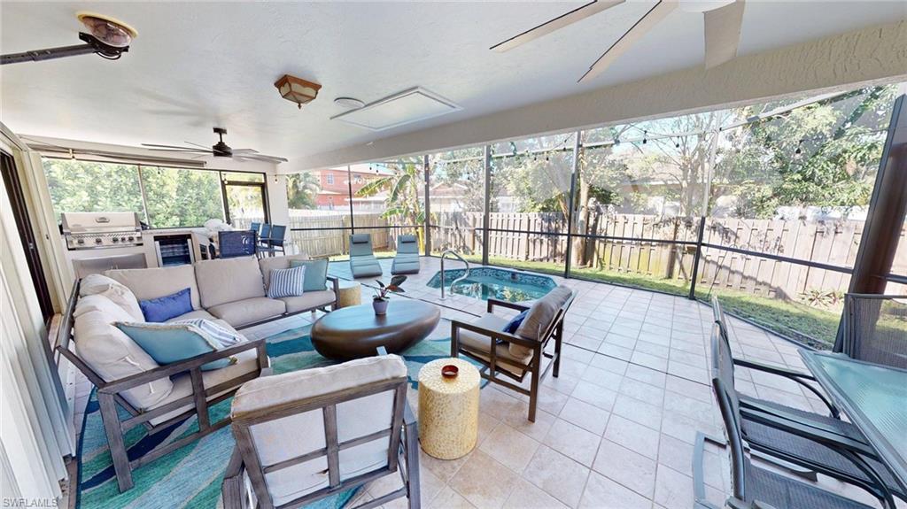 Lanai with ceiling fans, outdoor lounge area with lots of seating, a hot tub/plunge pool, outdoor kitchen, fully screened.