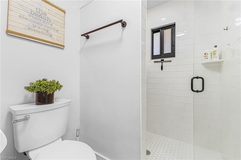 Primary modern bathroom with a walk-in tile shower featuring rain shower, 2nd shower head and water closet