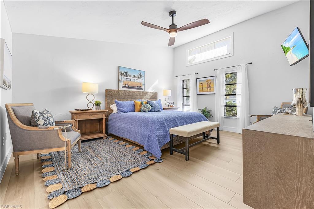 Primary Bedroom featuring a King size bed, a ceiling fan, TV, sitting area and vaulted ceiling