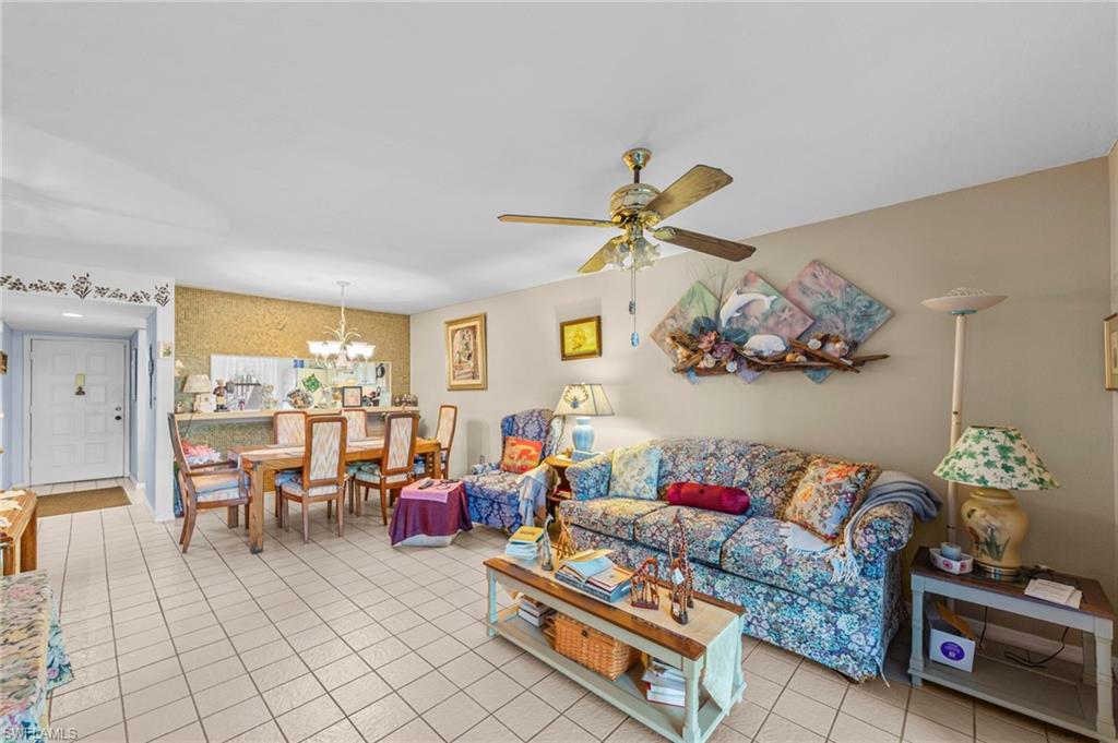 Living area featuring ceiling fan, hanging lights, and light tile patterned flooring