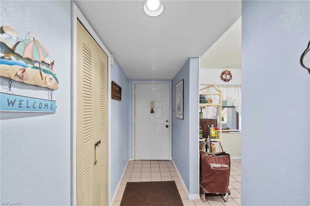Doorway to outside featuring tile patterned flooring and a textured wall
