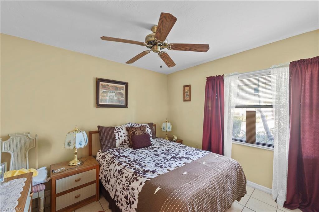 Bedroom with light tile patterned floors and ceiling fan