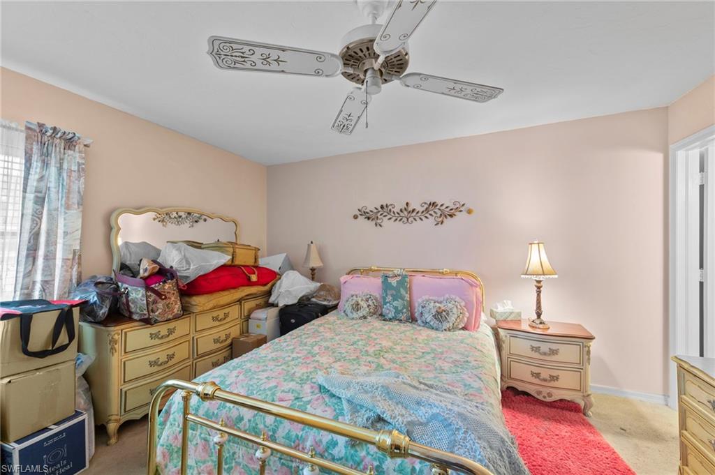 Bedroom with light carpet and a ceiling fan
