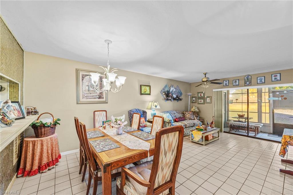 Dining space featuring a ceiling fan, suspended lighting, and light tile patterned flooring