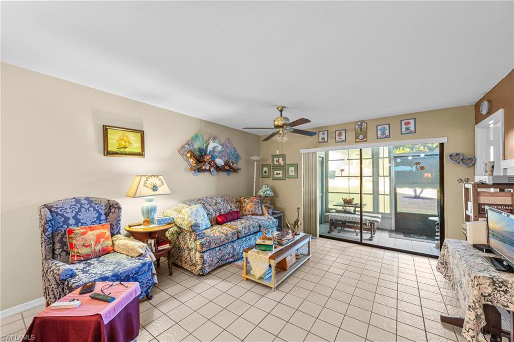 Living room with a ceiling fan and light tile patterned floors